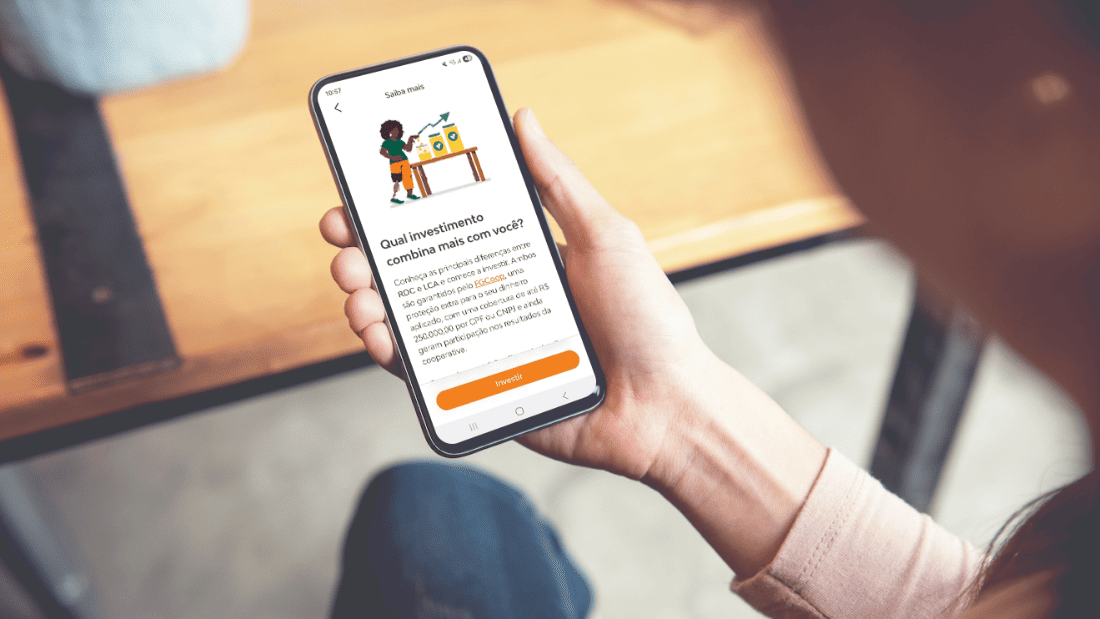 Jovem lendo no celular um artigo sobre qual investimento combina mais com você