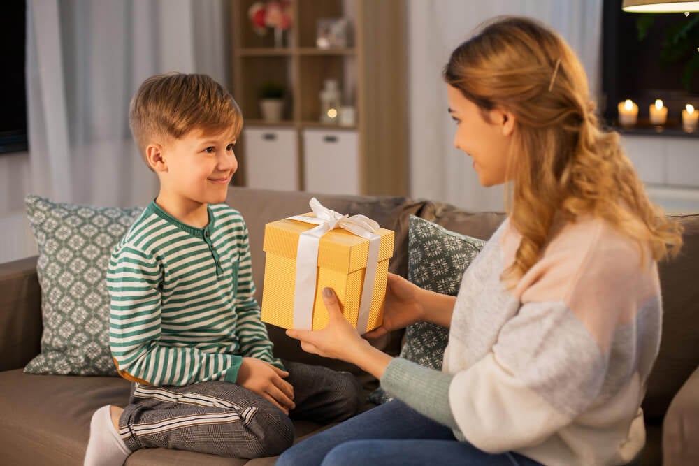 Mãe entregando presente para filho criança
