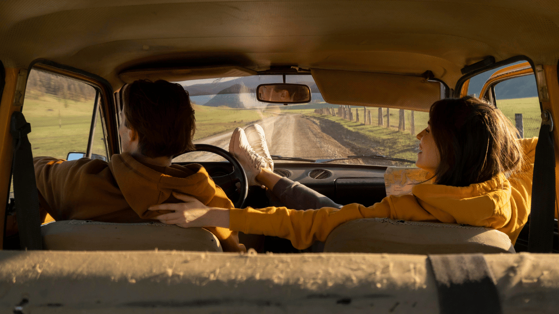 Imagem de casal na estrada, em um carro, para ilustrar o artigo sobre road trip