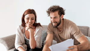 Foto de um casal conversando no sofá para ilustrar artigo sobre tabela para juntar dinheiro